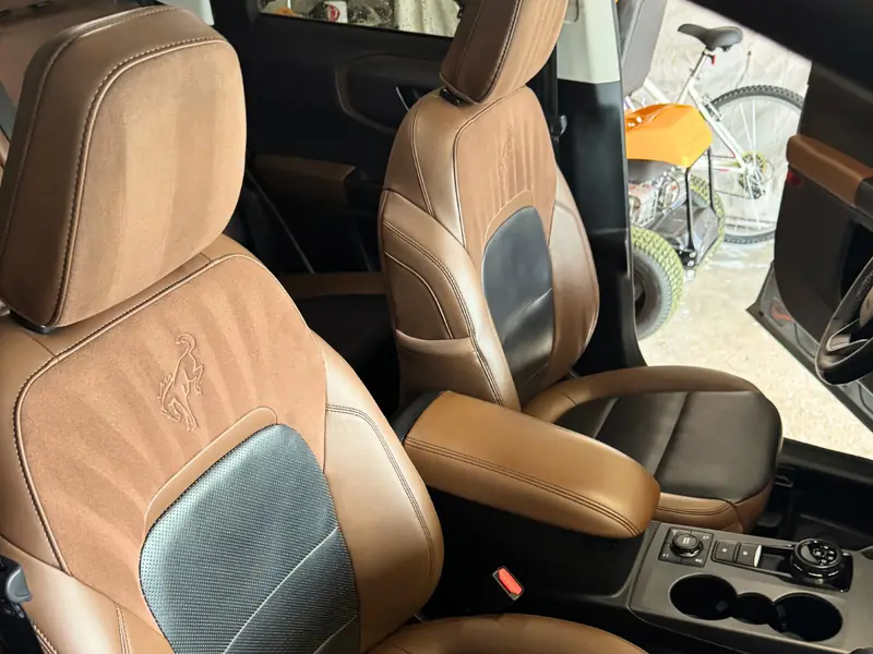 Beige fabric and leather hybrid seats detailed - passenger angle