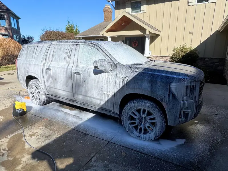 Black SUV covered in premium wash suds during exterior detailing service