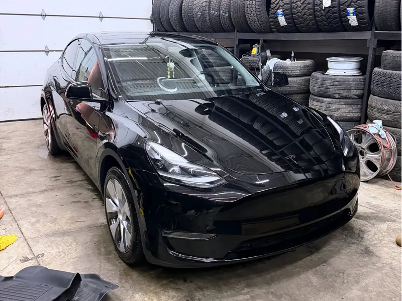 Black Tesla passenger side exterior after professional detailing - showroom finish