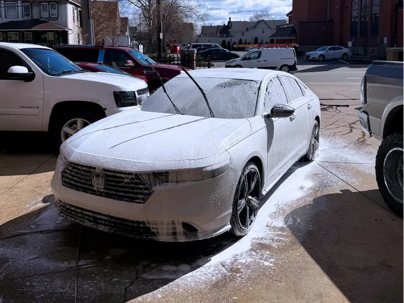 White Honda driver side receiving professional foam wash treatment